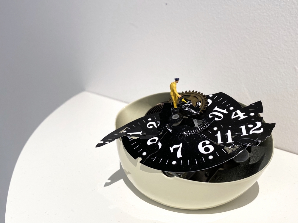 Liliana Porter, To Fix It [Man in Yellow], 2020. Broken table clock and figurine, 3 x 4 1/2 x 3 in.